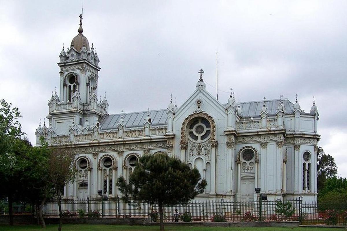 một tòa nhà màu trắng có một tháp đồng hồ trên đỉnh