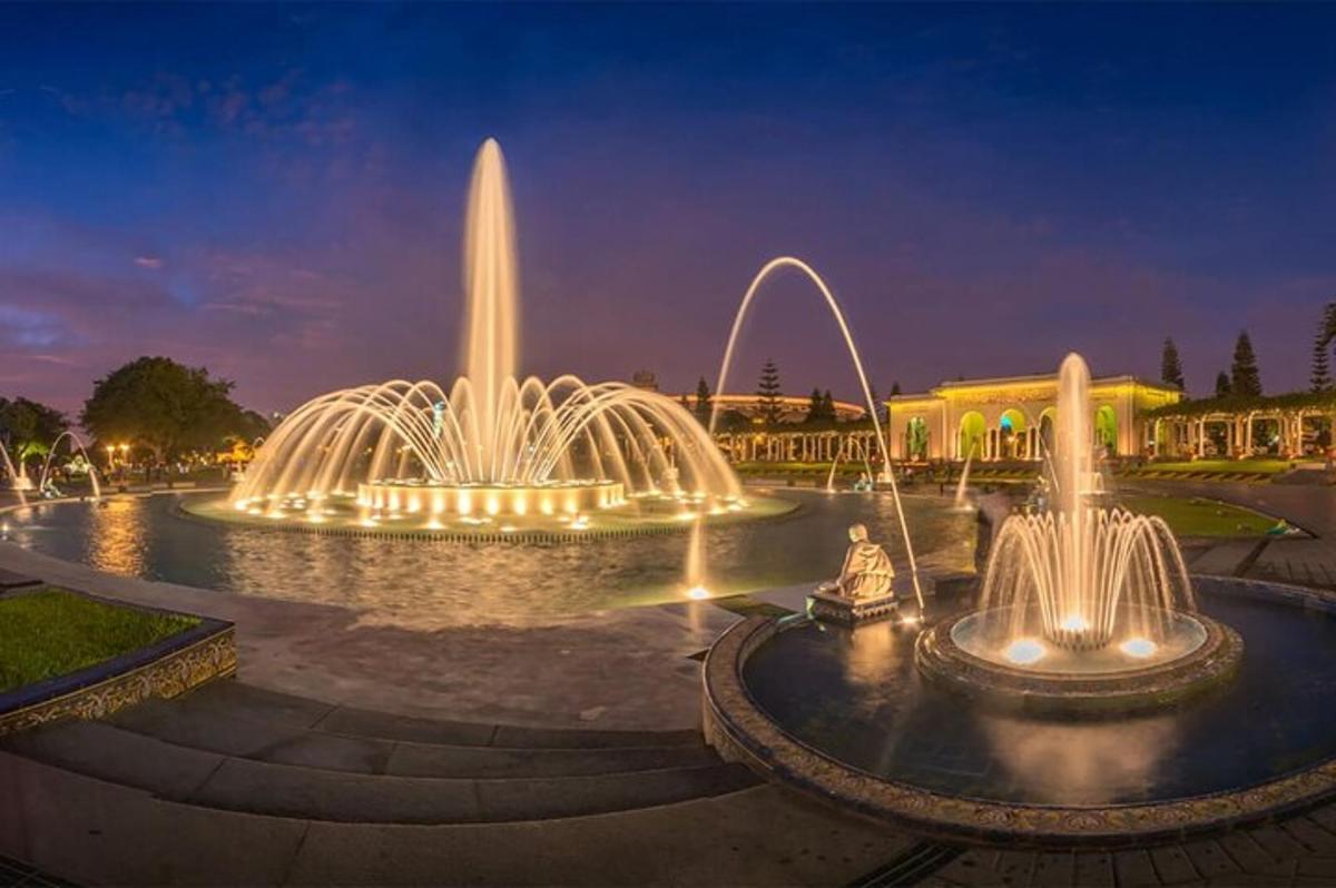 un grup de fonts d'aigua en un parc a la nit