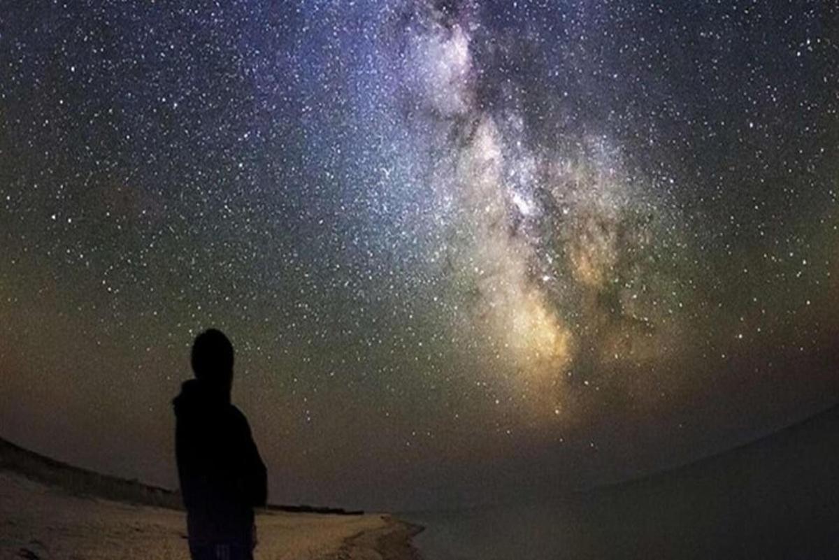 a man standing in front of a starry sky