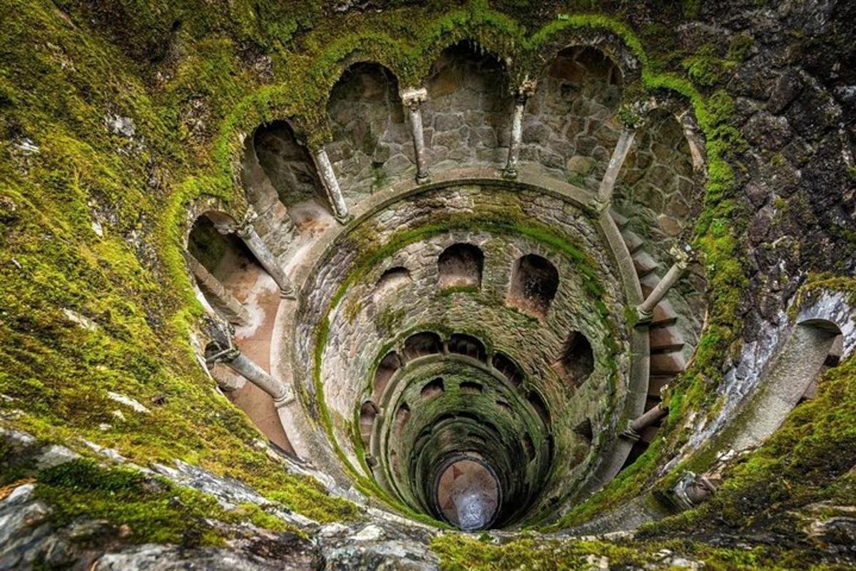 an old tunnel with moss on the side of a mountain