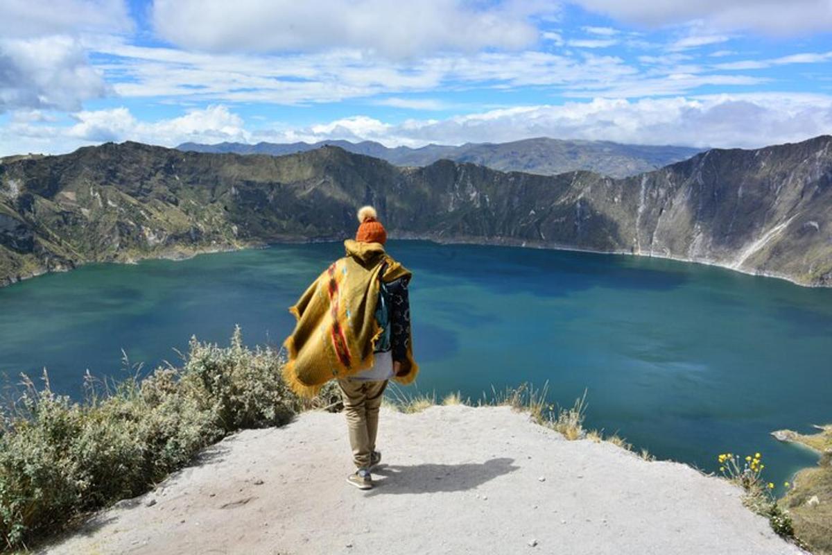 a man walking up a hill overlooking a lake