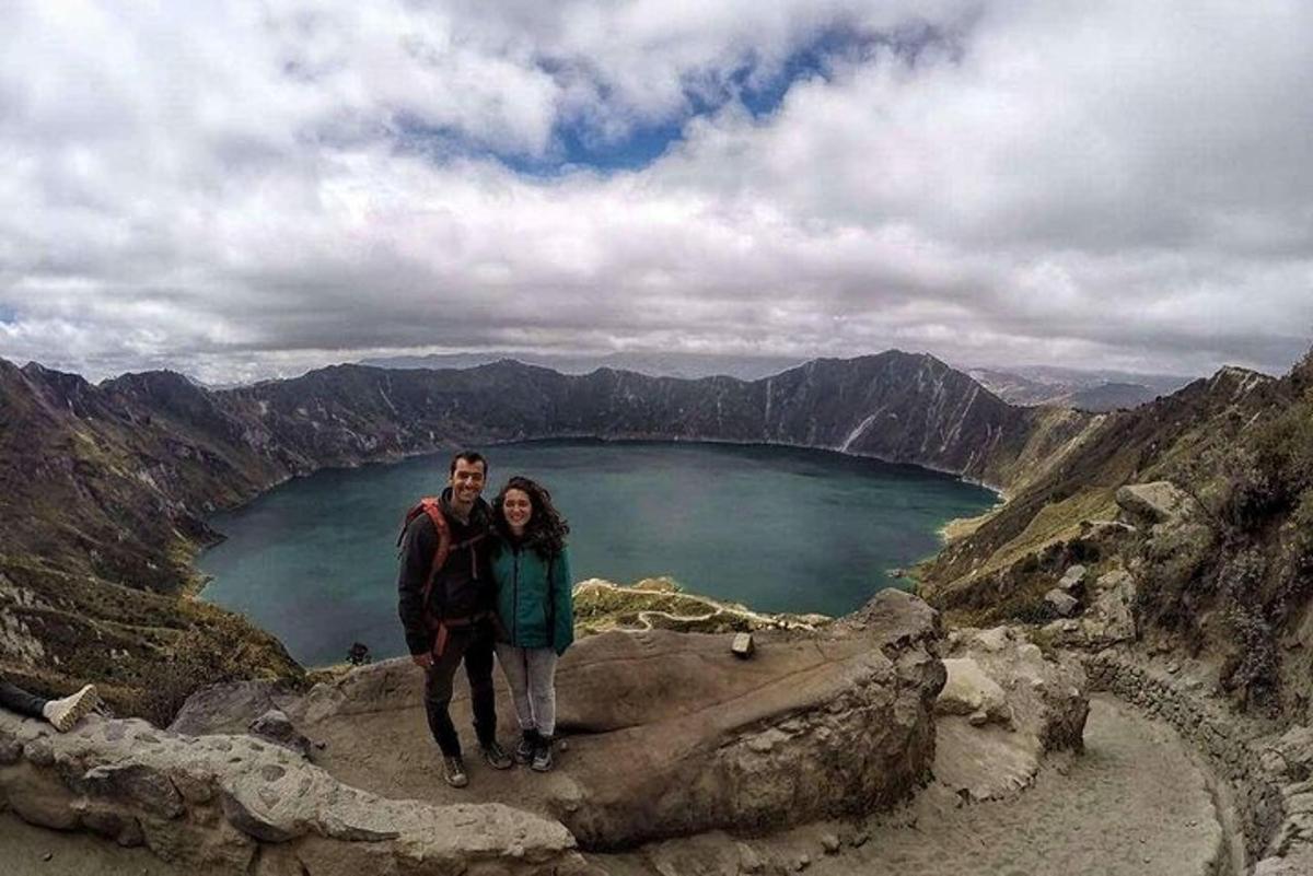 a man and woman standing on top of a mountain