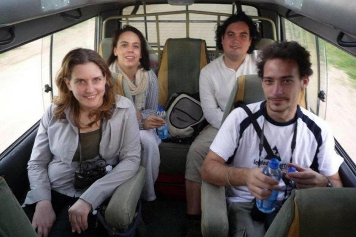 un grup de oameni care stau în spatele unui autobuz