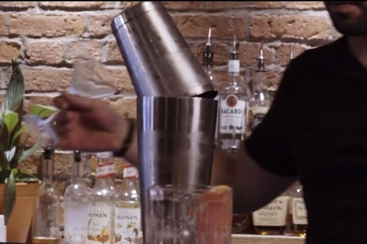 muž si v baru dělá drink