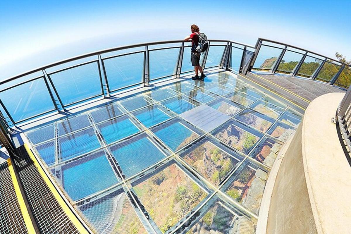 un uomo in piedi sul pavimento di vetro di un ponte di osservazione
