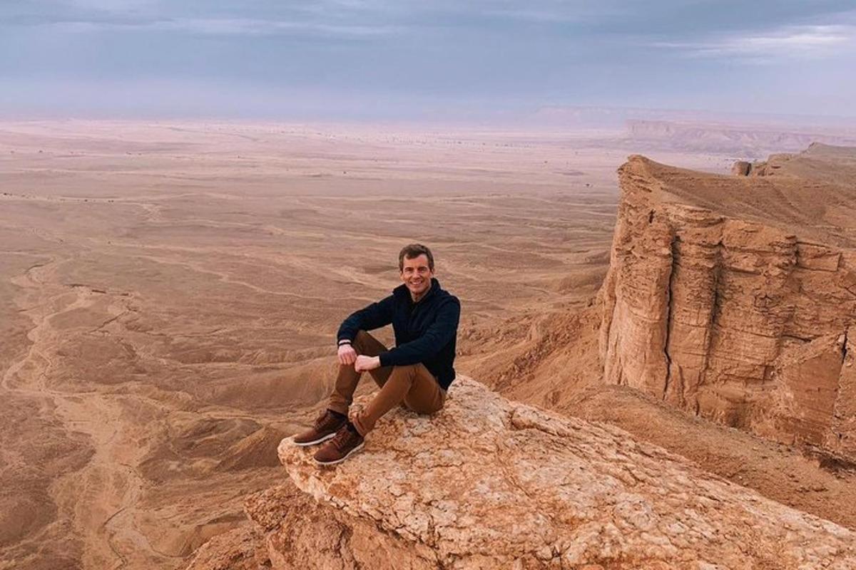 un uomo seduto su una roccia nel deserto