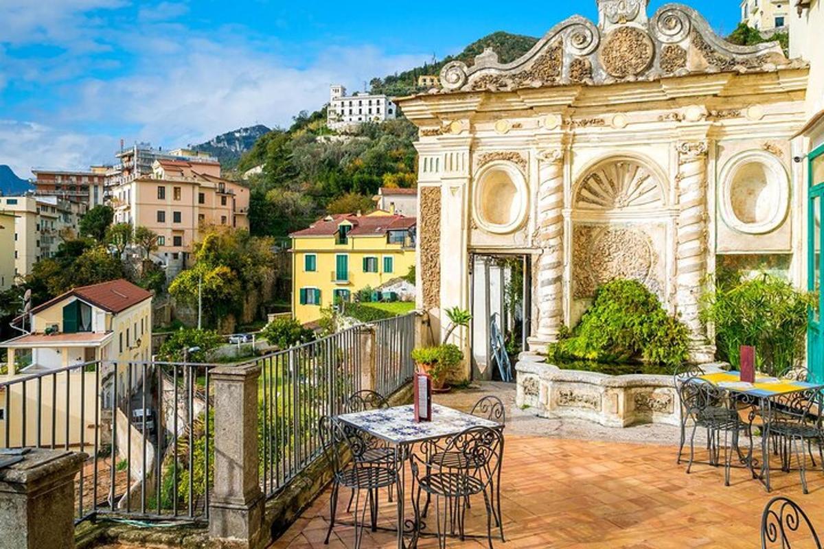 ein Balkon mit Tischen und Stühlen und Blick auf die Stadt