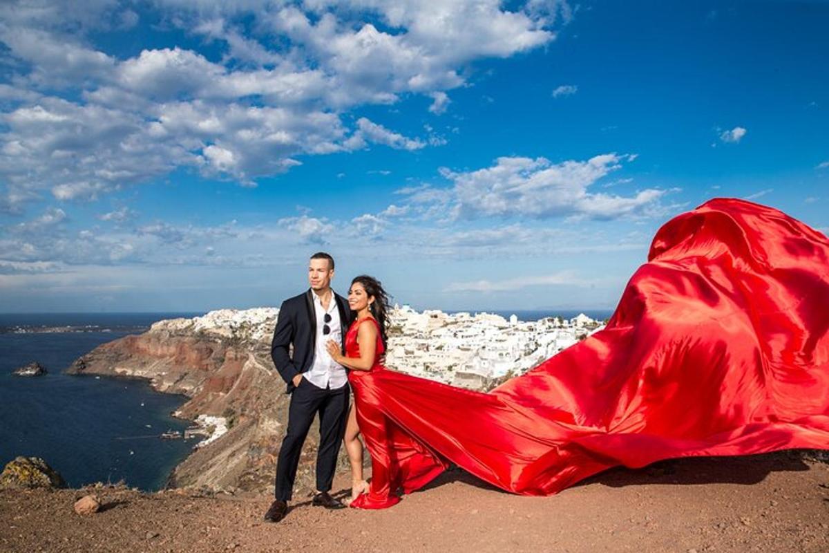 Un hombre y una mujer de pie en la cima de una montaña con un vestido rojo.