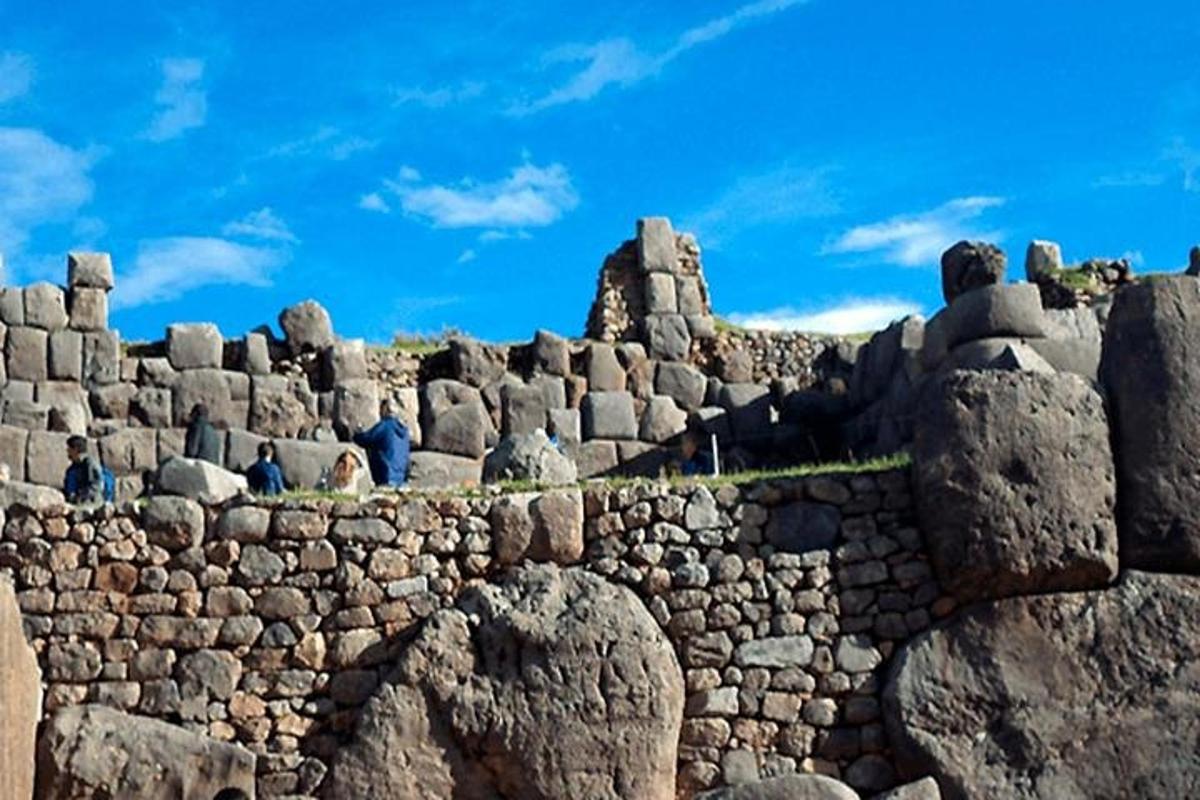 un mur de pedra amb gent asseguda a sobre