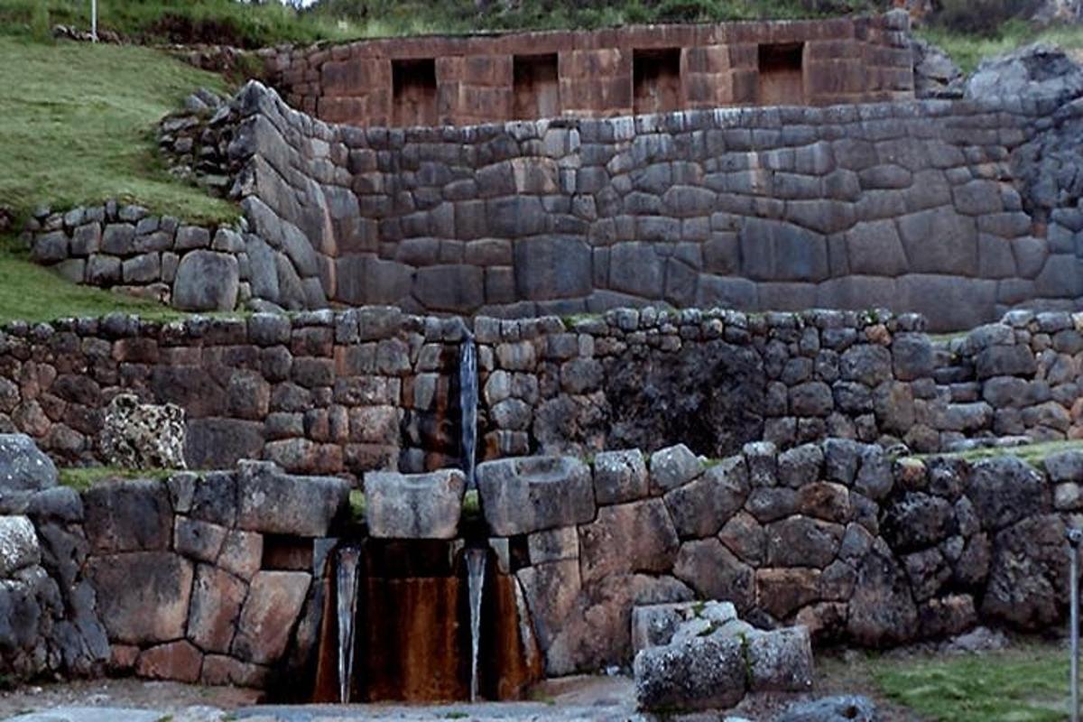 un mur de contenció de pedra amb una font d'aigua