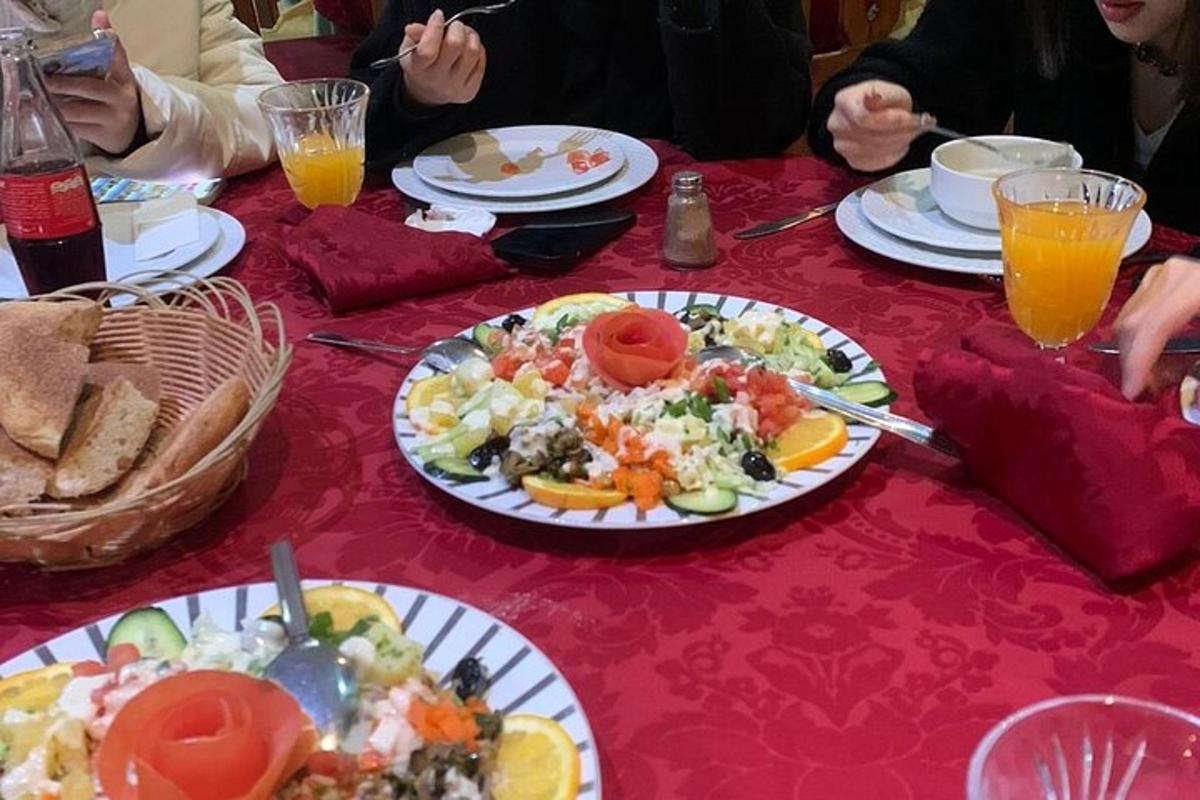 skupina lidí sedících u stolu s talíři jídla