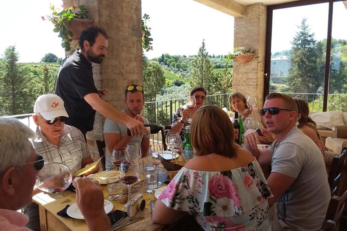 Un grupo de personas sentadas alrededor de una mesa con copas de vino.