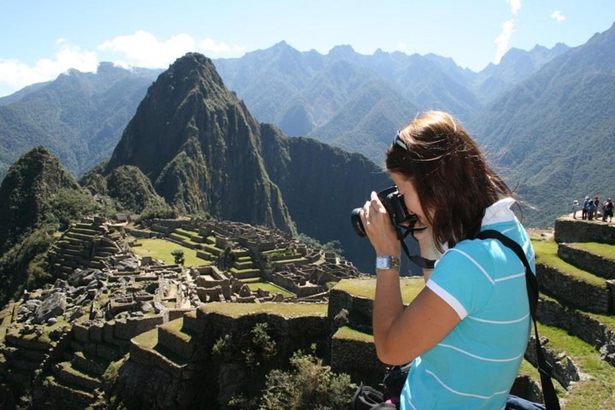 Una mujer tomando una fotografía de unas ruinas
