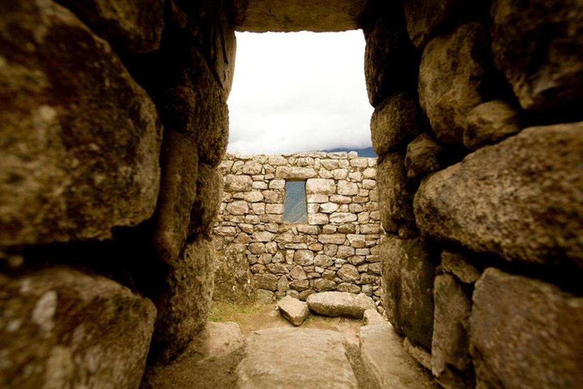 Una vista de un edificio de piedra a través de una ventana de piedra.