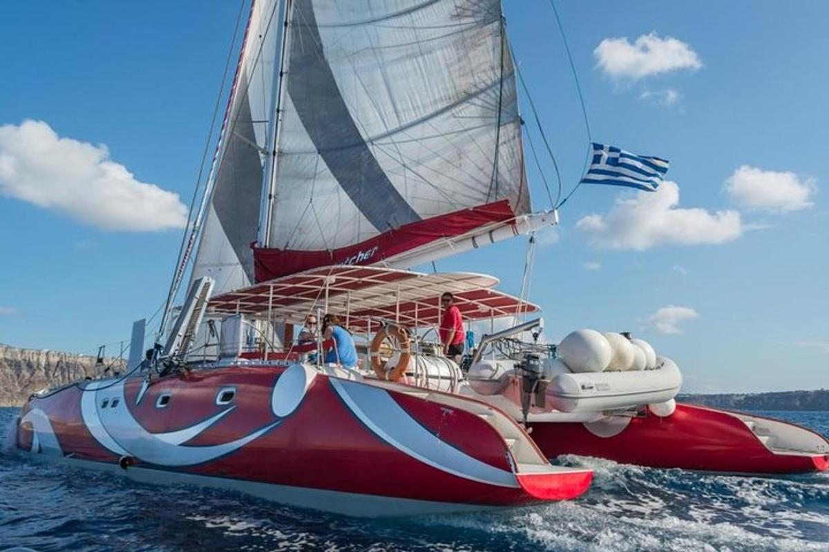 ένα κόκκινο και άσπρο ιστιοφόρο στο νερό