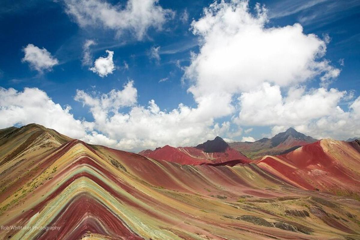 pemandangan gunung yang berwarna-warni di bawah langit yang mendung