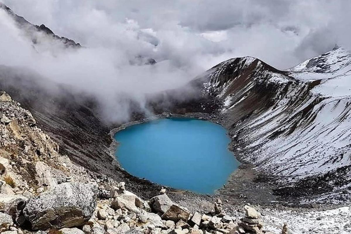 um lago azul na encosta de uma montanha coberta de neve