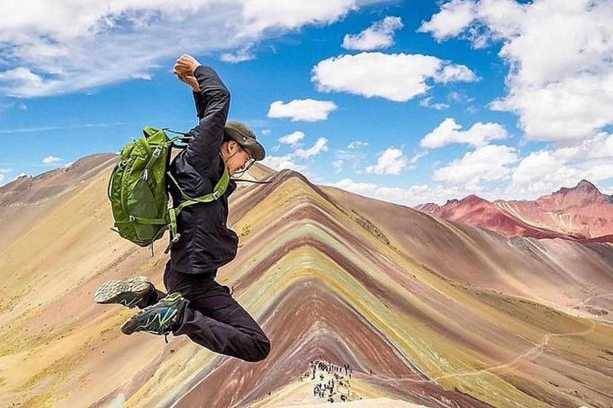 a man with a green backpack jumping in the air