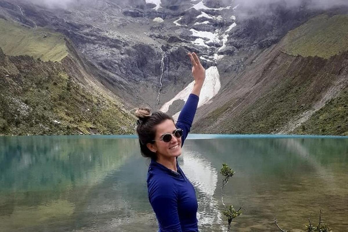 una donna in piedi davanti a un lago di montagna