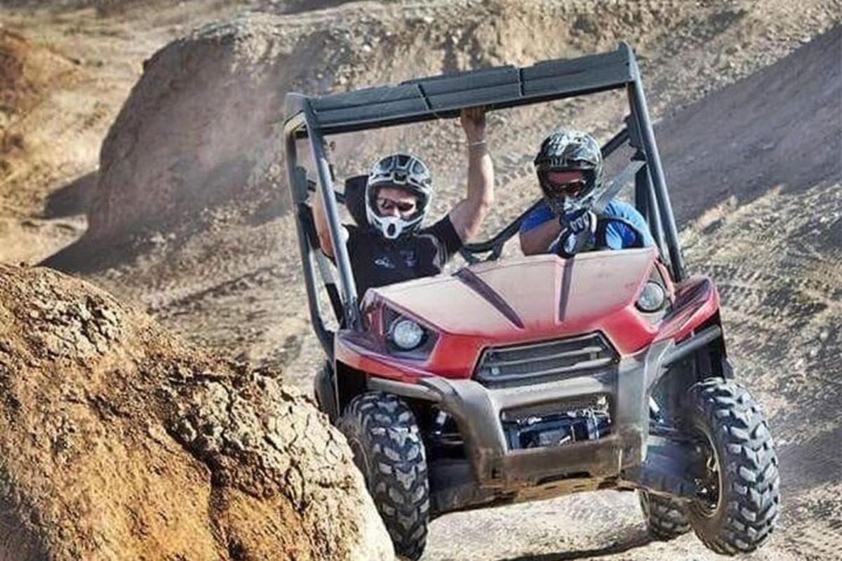 dua orang menaiki atv di jalan tanah