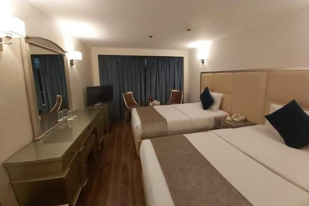 una camera d'albergo con due letti e una televisione