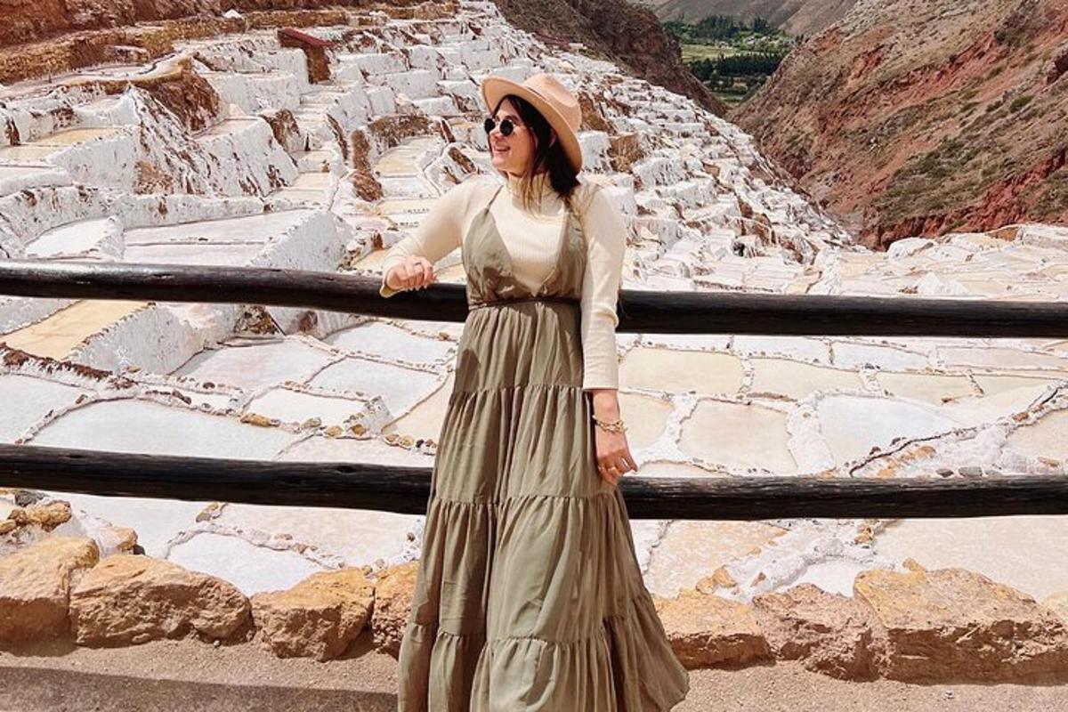 Una mujer con un vestido apoyada en una valla