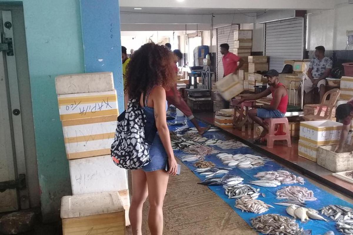 una donna in piedi in un mercato che guarda i frutti di mare