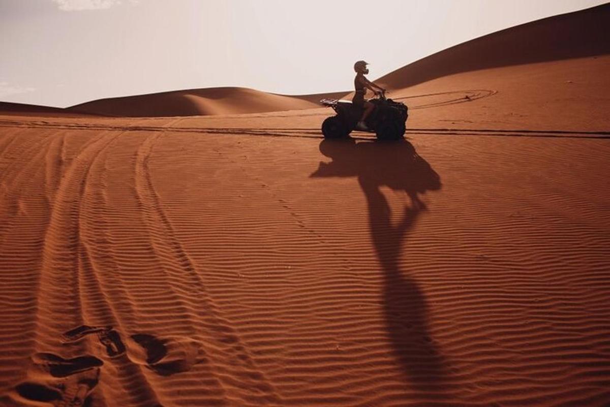 una persona que condueix una motocicleta al desert