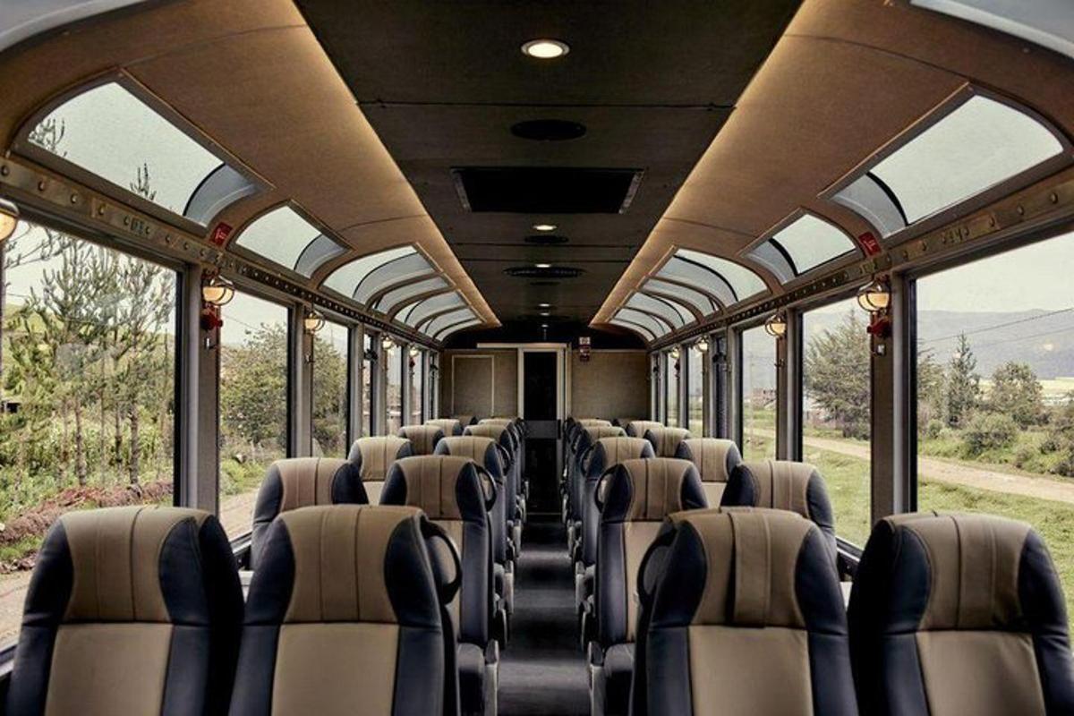 Un vagón de tren vacío con sillas y ventanas.