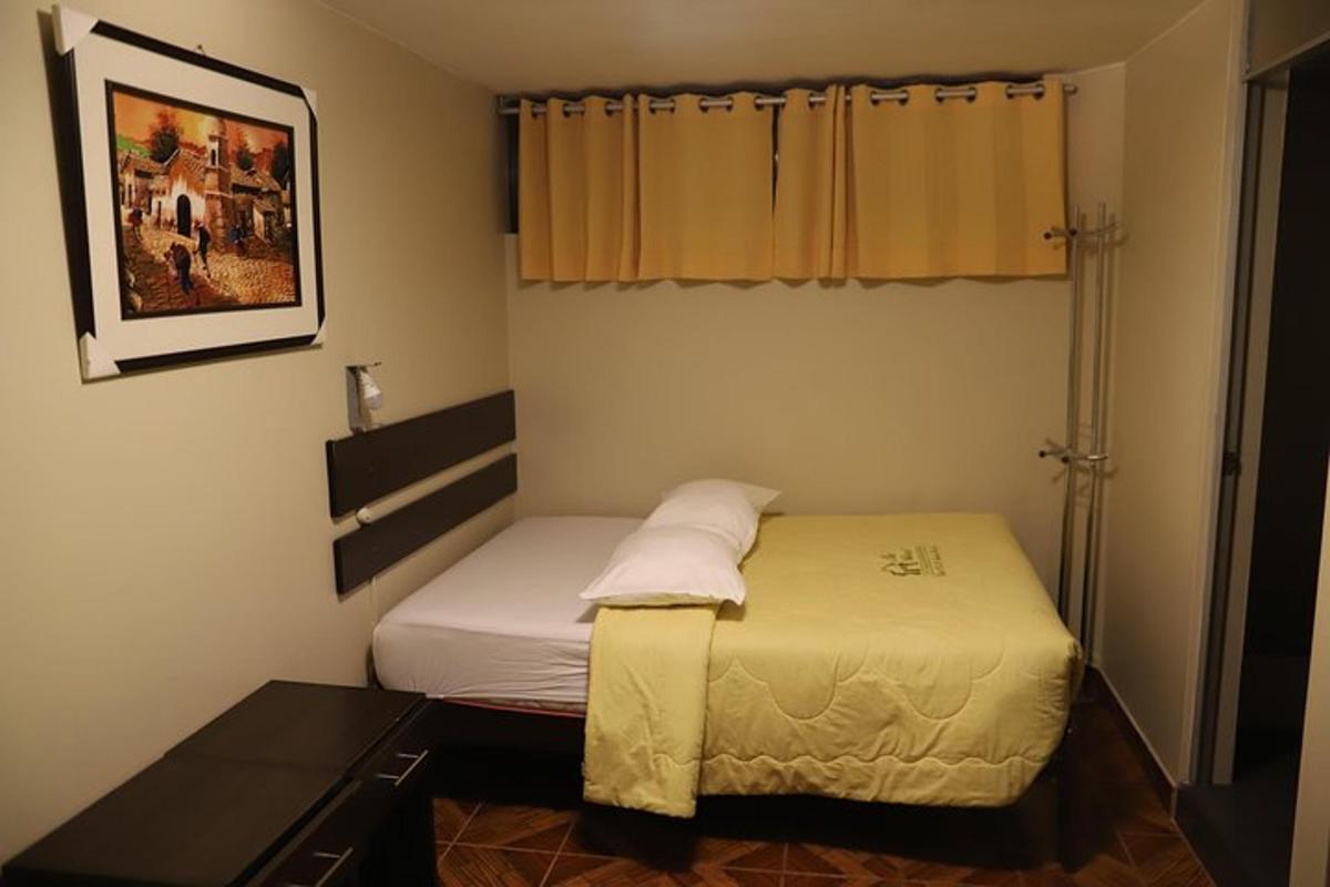 Una pequeña habitación con una cama y una ventana.
