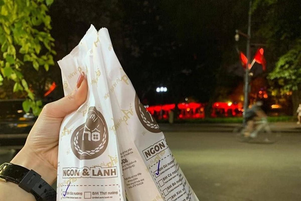 ένα άτομο που κρατάει ψηλά μια σακούλα με φαγητό