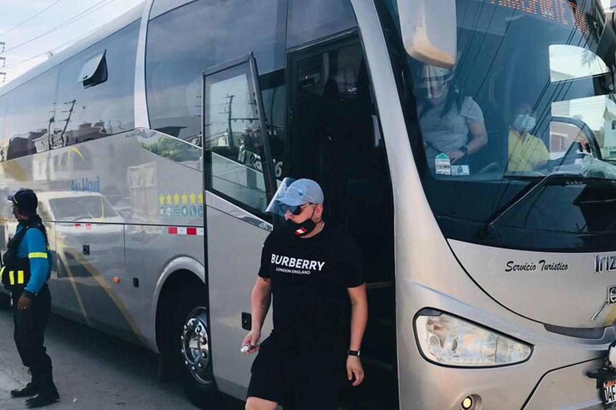 un bărbat stă în fața unui autobuz