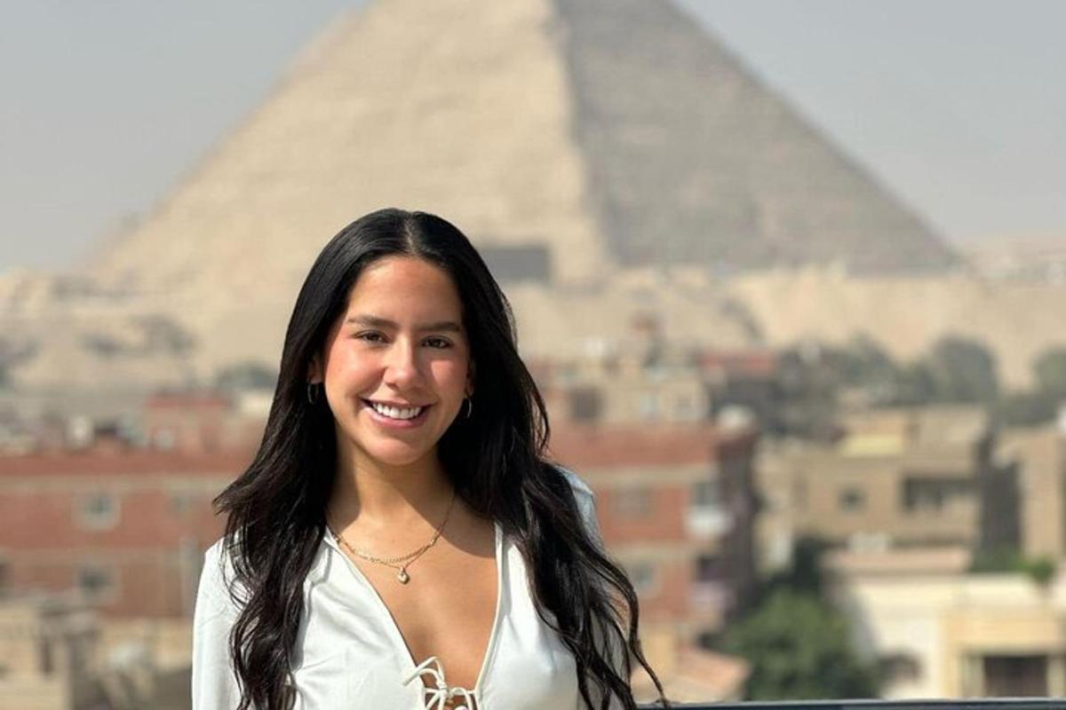 Žena stojí pred pyramídou