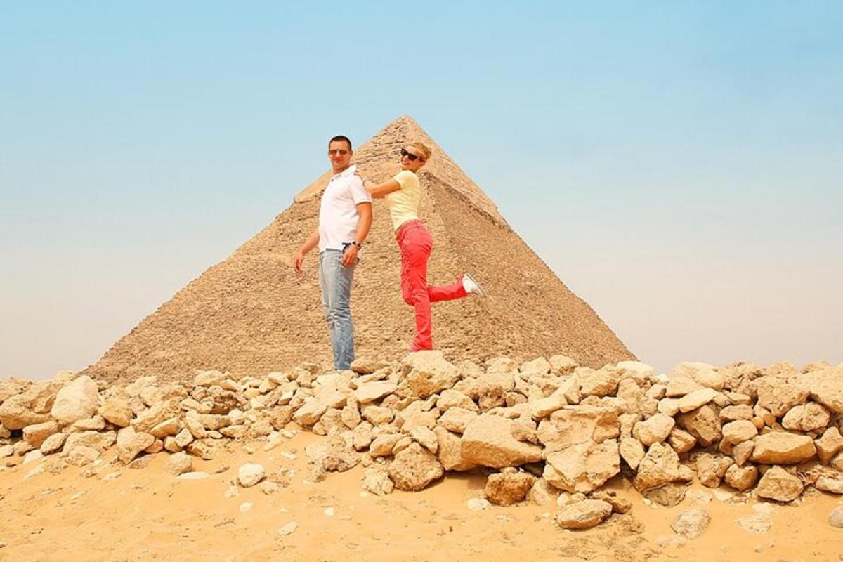 en mann og en kvinne som står foran en pyramide