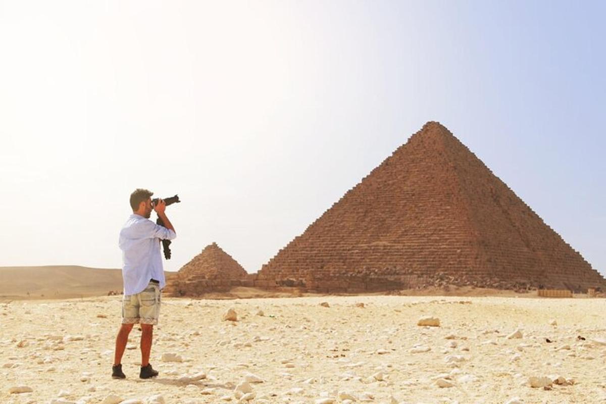 en mann som tar et bilde av pyramidene