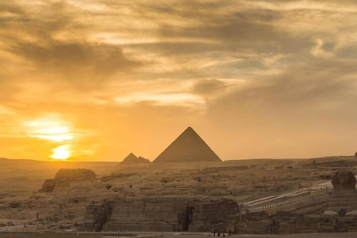 uma vista das pirâmides de Gizé ao pôr do sol