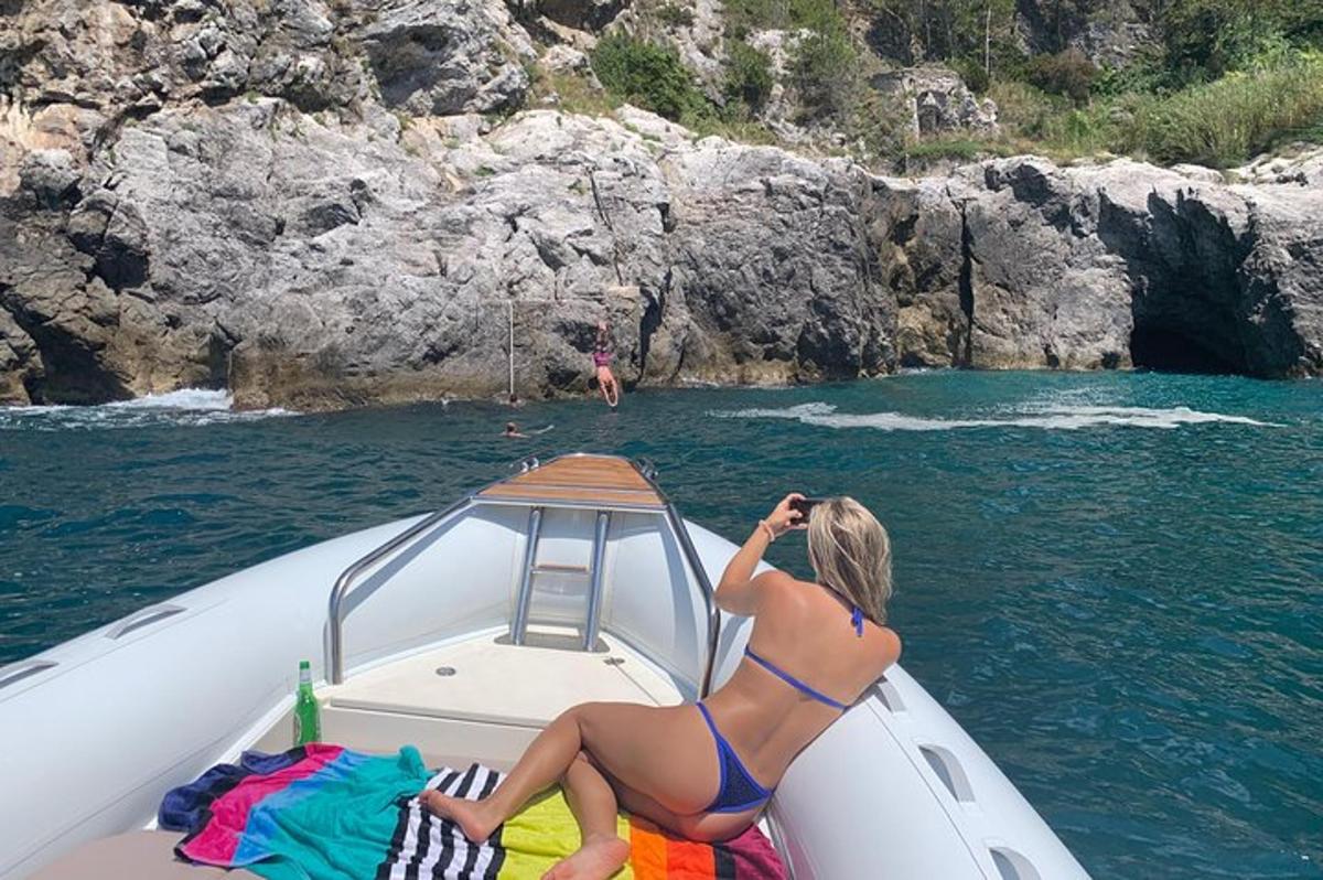 žena v bikinách sedící na lodi ve vodě