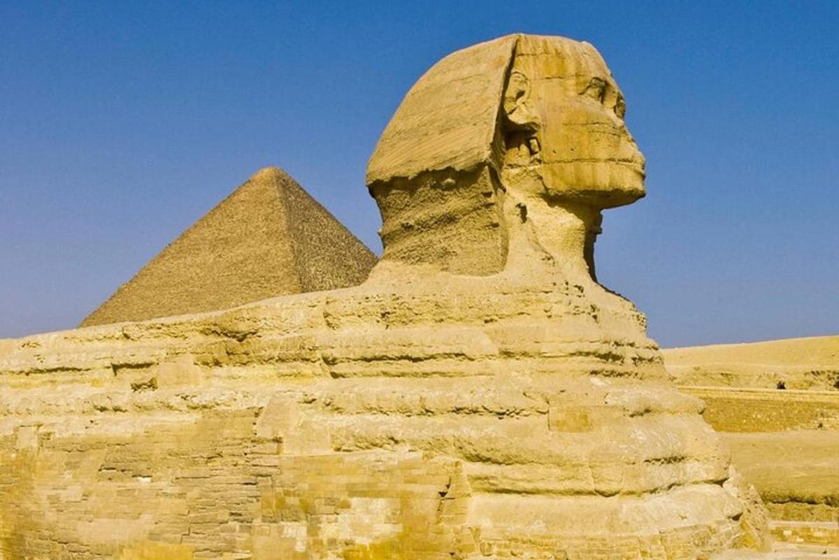 uma estátua em frente à esfinge e à pirâmide