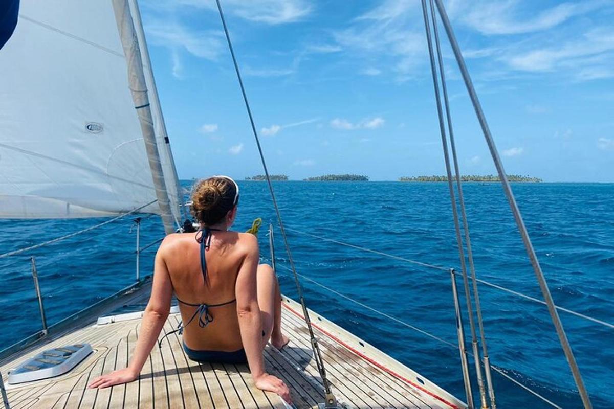 isang babaeng naka-bikini na nakaupo sa isang layag na bangka