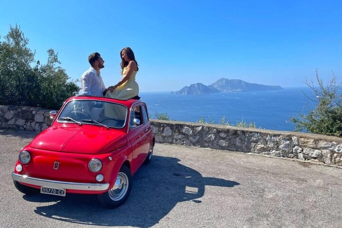 um homem e uma mulher sentados em cima de um carro vermelho