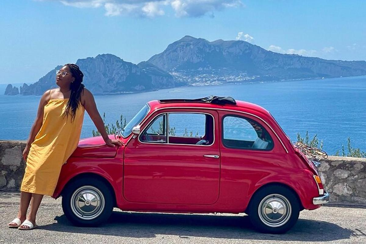 uma mulher de vestido amarelo parada ao lado de um carro vermelho