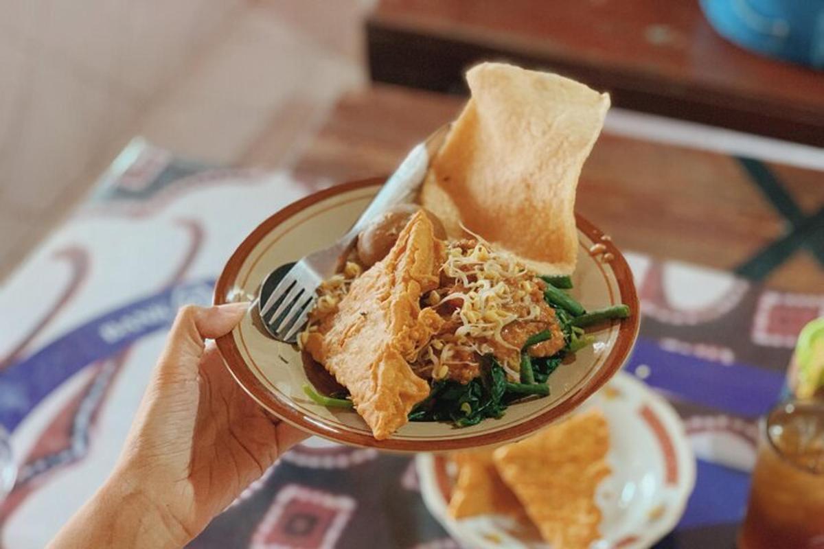 una persona que sosté un plat de menjar amb un entrepà