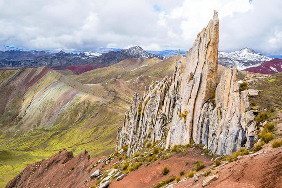 ein großer felsiger Berg mit schneebedeckten Bergen im Hintergrund