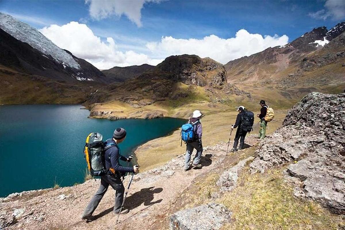 un gruppo di persone che camminano su una montagna vicino a un lago