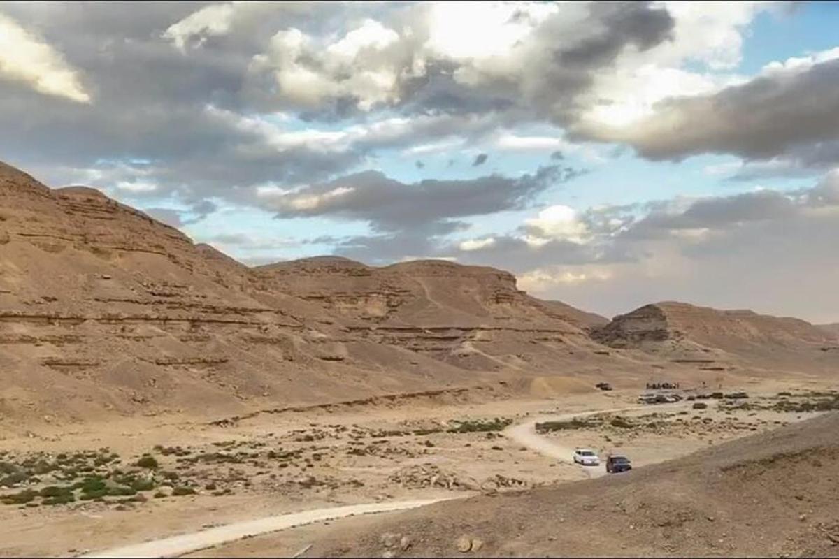 un camino de tierra en un desierto con montañas