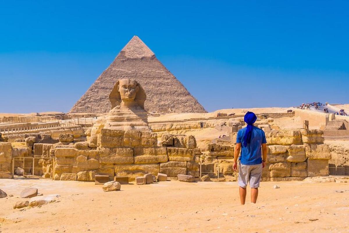 muž stojící před pyramidami