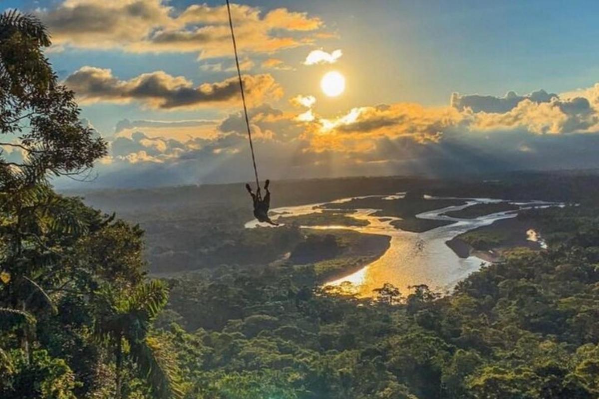 a person on a rope swing over a river