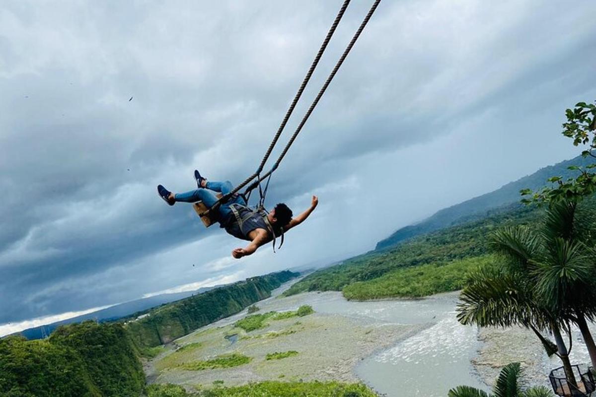 a person on a rope swing over a river