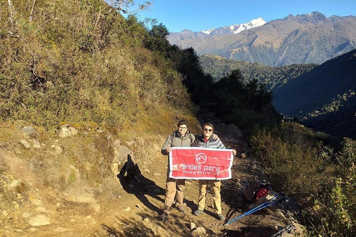 due persone che tengono un cartello su una montagna