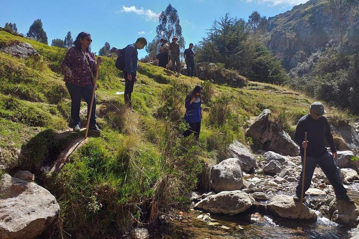 un gruppo di persone che camminano su una collina vicino a un fiume